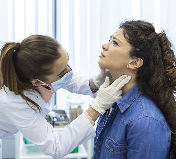 Une infirmière palpe la gorge d'une patiente - MACSF