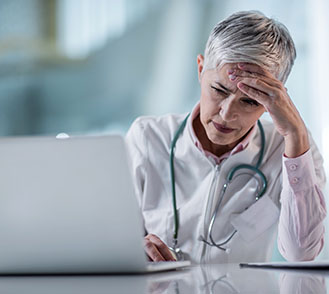 Une femme médecin se tient la tête - MACSF