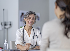 Une femme médecin à son bureau avec une patiente - MACSF