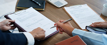 Gros plan sur une main qui s'apprête à signer un document à l'endroit désigné par son interlocuteur - MACSF
