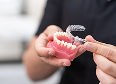 Un orthodontiste présente un moulage de mâchoire et une gouttière dentaire - MACSF