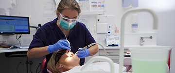 Une femme chirurgien-dentiste pratique des soins sur une patiente - MACSF