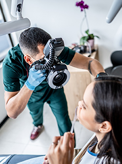 Un chirurgien-dentiste prend une photo de la bouche de sa patiente - MACSF