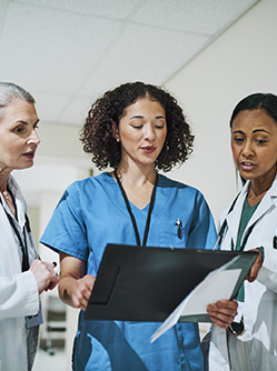 Trois fonctionnaires hospitaliers discutent dans le couloir de l'hôpital - MACSF