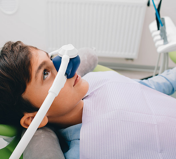 Jeune garçon, sur le fauteuil du dentiste, portant un masque pour l'administration de meopa - MACSF