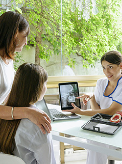 Une mère et sa fille mineure regardent la tablette présentée par la dentiste - MACSF