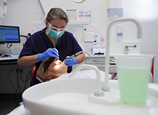 Une femme chirurgien-dentiste pratique des soins sur une patiente - MACSF