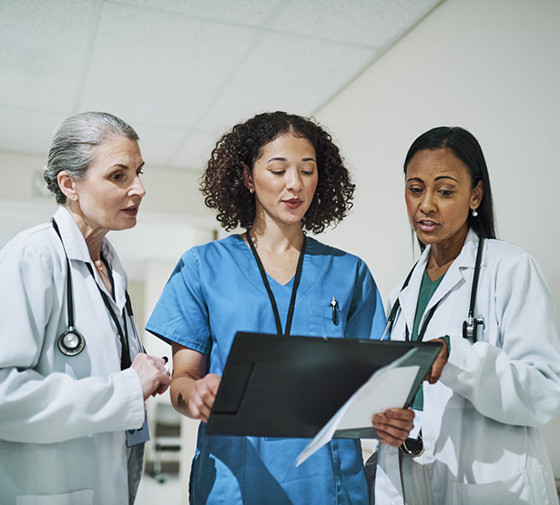 Trois fonctionnaires hospitaliers discutent dans le couloir de l'hôpital - MACSF