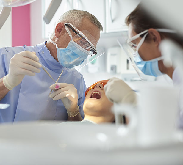 Un chirurgien-dentiste pratique des soins sur une patiente - MACSF