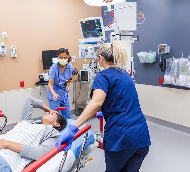 Deux infirmières du service des urgences de l'hôpital accueillent une femme sur un brancard - MACSF