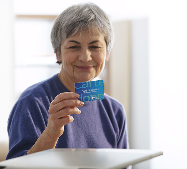 Une femme tient une carte de donneur d'organes - MACSF