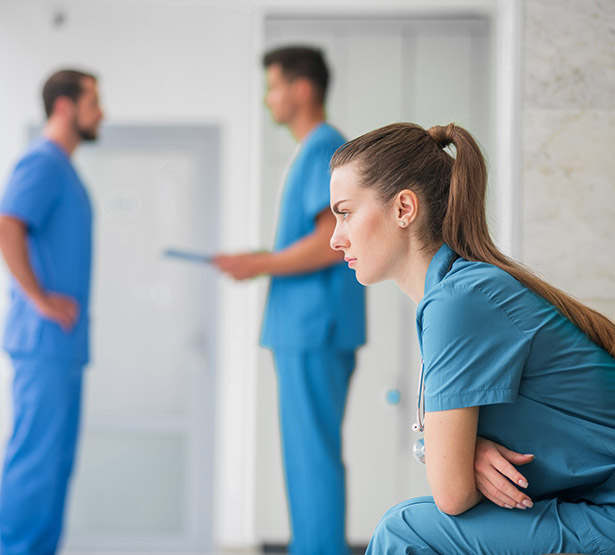 Un femme pensive est assise dans le couloir de l'hôpital - MACSF