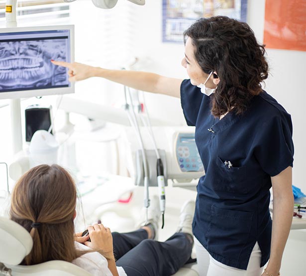 Une femme chirurgien-dentiste explique les soins à sa patiente - MACSF