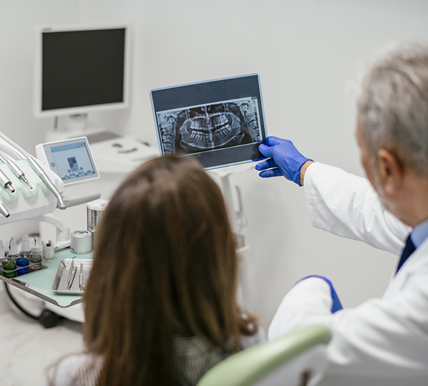 Le dentiste montre une radio dentaire à la patiente - MACSF