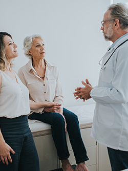 Le médecin discute avec une patiente âgée qui est accompagnée de sa fille - MACSF