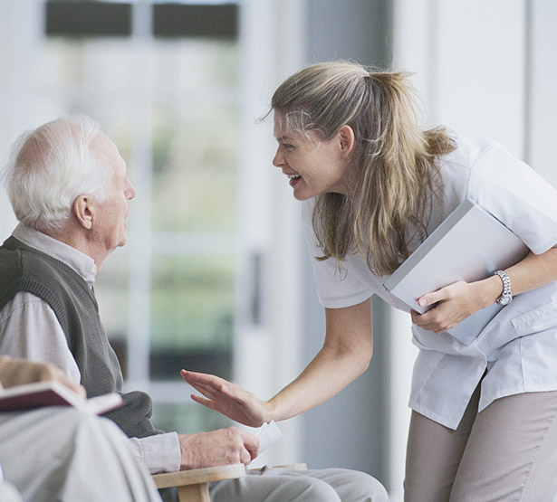 Soignante souriante devant un homme agé  - MACSF