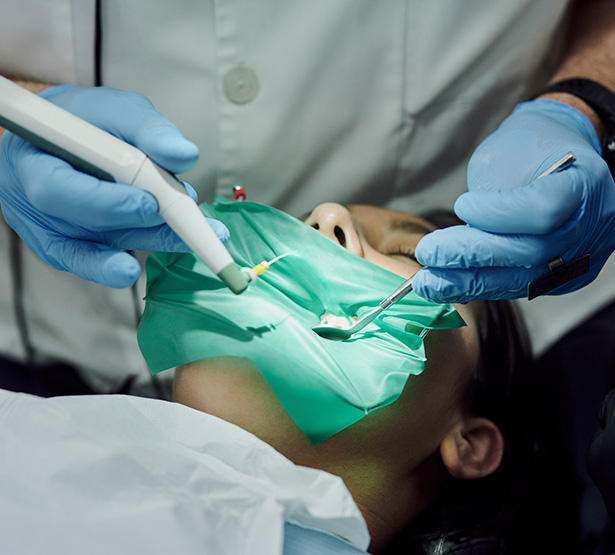 Un chirurgien-dentiste pratique des soins sur une patiente - MACSF