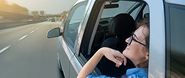 Femme assise à l'arrière d'une voiture autonome - MACSF