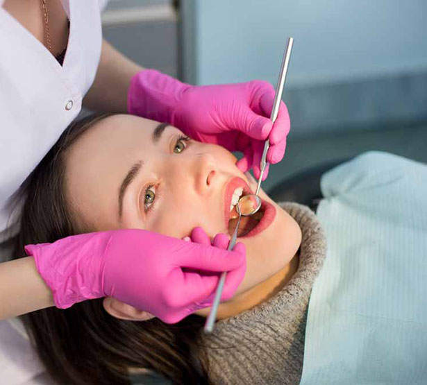 Une femme chirurgien-dentiste réalise des soins sur une patiente | MACSF