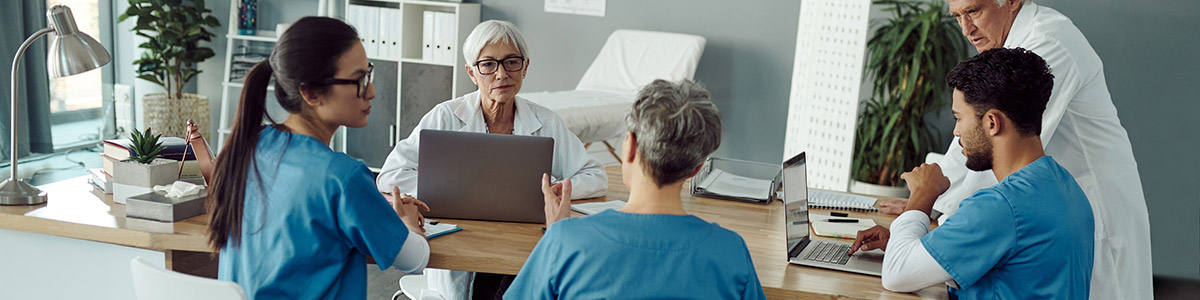 Des professionnels de santé examinent un dossier autour d'une table - MACSF