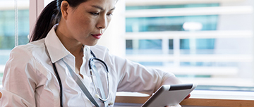 Une femme médecin regarde sa tablette - MACSF