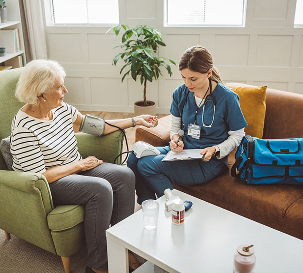 Une infirmière à domicile prend la tension d'une patiente âgée - MACSF