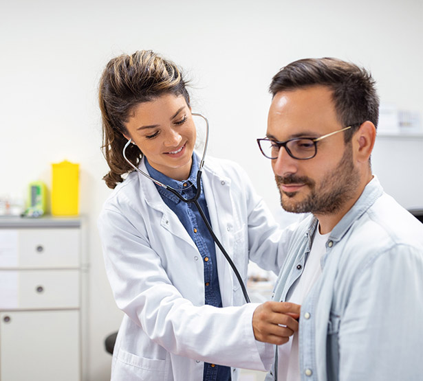 Une interne en médecine ausculte un patient au cabinet - MACSF