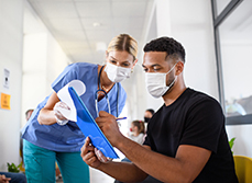 Une interne en médecine fait signé un document à un patient - MACSF