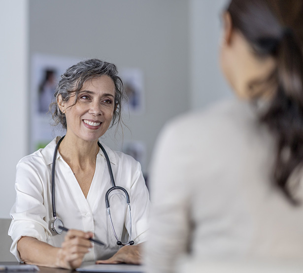 Une femme médecin à son bureau avec une patiente - MACSF