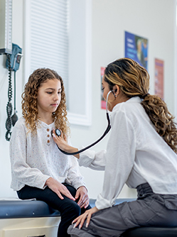 Une femme médecin ausculte une adolescente - MACSF