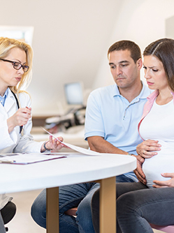 Une femme enceinte et son marie en consultation chez le médecin - MACSF