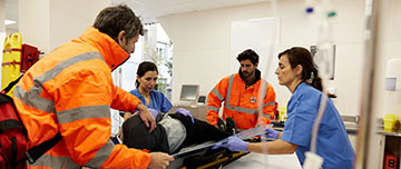 Des secouristes aident l'équipe hospitalière à installer un blessé - MACSF