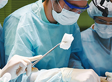 Une infirmière fait passer une compresse au chirurgien lors d'une intervention - MACSF