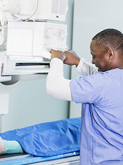 Un manipulateur radio installe le patient sur la table d'examen - MACSF