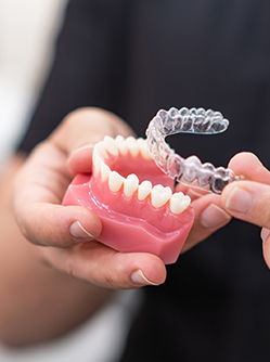 Un orthodontiste présente un moulage de mâchoire et une gouttière dentaire - MACSF