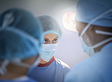 Une femme chirurgien regarde un de ses confrères lors d'une intervention - MACSF