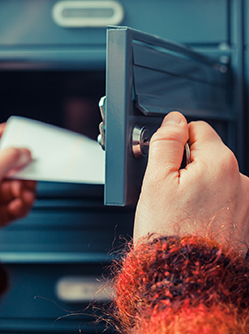 Mains d'une femme retirant le courrier de sa boite aux lettres - MACSF