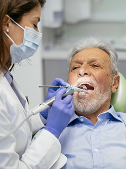 Une femme chirurgien-dentiste soigne un patient - MACSF