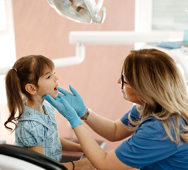 La dentiste examine les dents d'une fillette - MACSF