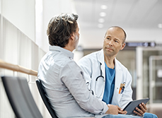 Un médecin discute avec un patient dans le couloir d'un hôpital - MACSF