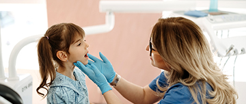 La dentiste examine les dents d'une fillette - MACSF