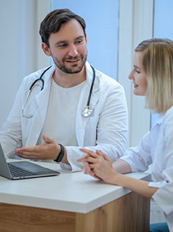 Discussion entre deux médecins devant l'ordinateur - MACSF